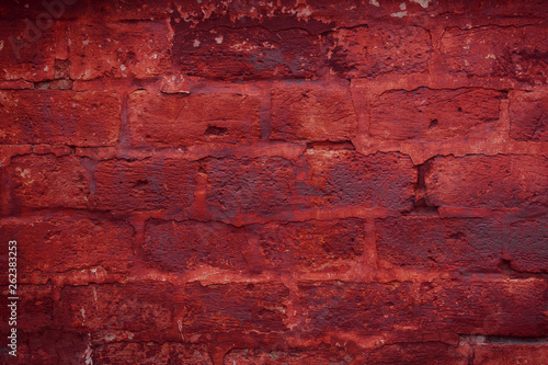 Old grungy brick wall. Free space for an inscription. Can be used as a background or poster. Fragment of a wall with bumps and peeling paint.