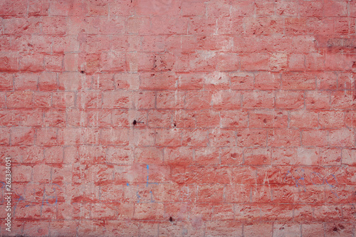 Old grungy brick wall. Free space for an inscription. Can be used as a background or poster. Fragment of a wall with bumps and peeling paint.