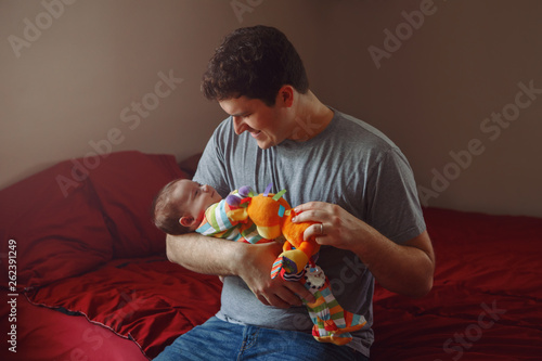Εκτύπωση καμβά Young Caucasian father playing with newborn baby