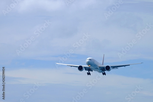 Airplane preparing for landing with white cloud background on cloudy blue sky day