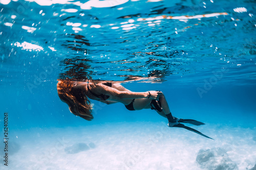 Woman freediver with fins relax in sea. Underwater in blue ocean