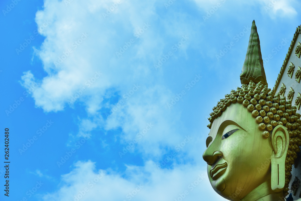 Yellow Buddha face in the blue sky,white clouds