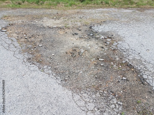 damaged or weathered or worn black asphalt road