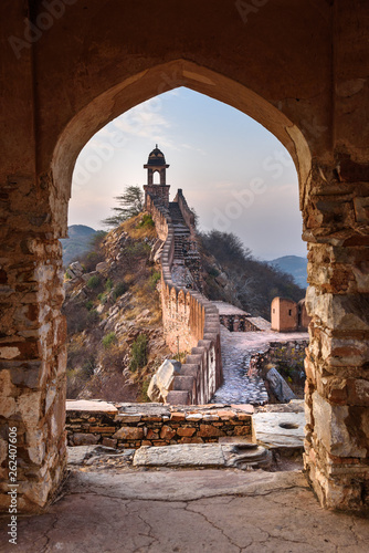 Obraz na płótnie Ancient long wall with towers around Amber Fort through the arch of tower walls at morning. Rajasthan. India w salonie