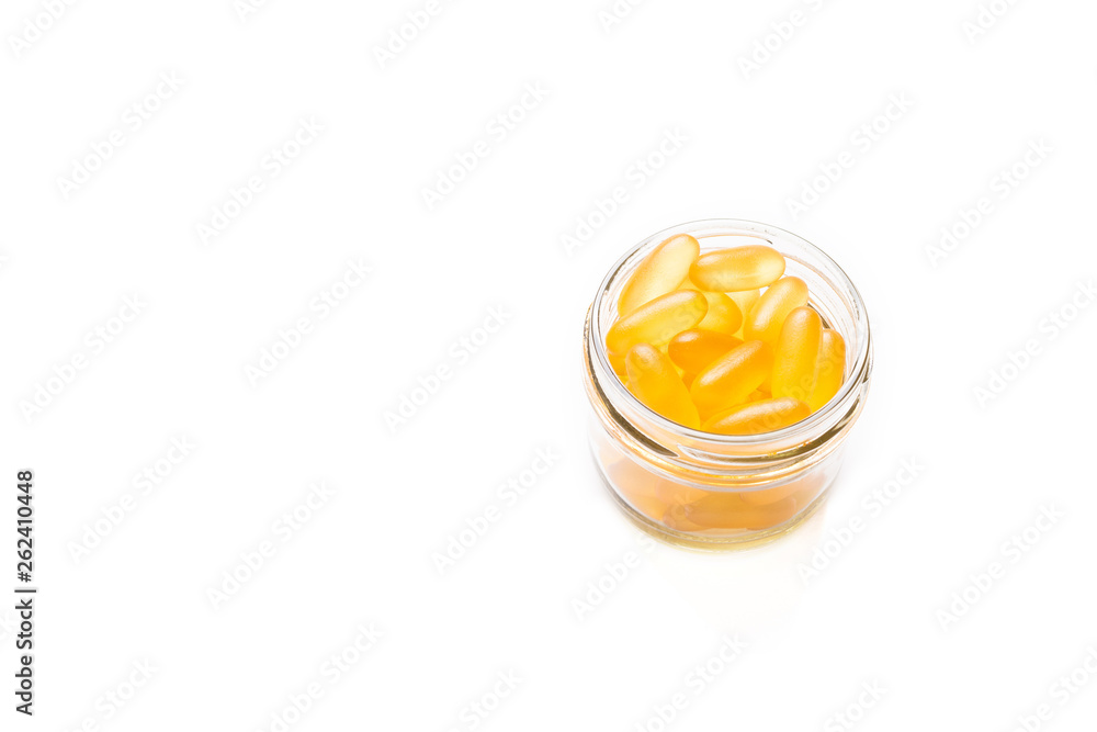 Omega 3 capsules in glass jar on white background Fish oil Yellow softgels Vitamin D, E, A supplement