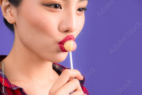 A glamorous girl eats chupachups, looks into the camera. photo