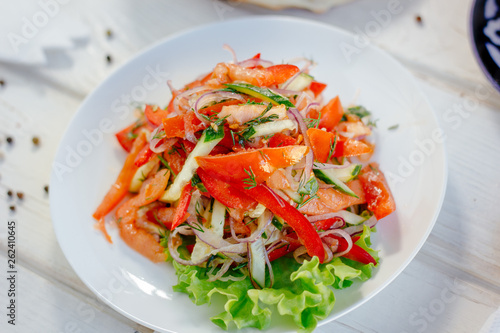 Vegetable salad on the white plate. Achik Chukchuk salad with tomatoes and onion.