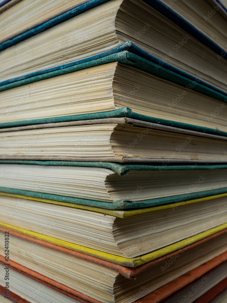 Heap of books of different flowers. The old books put on a table. The turned yellow pages of textbooks Heap of books of different flowers. The old books put on a table. The turned yellow pages of textbooks