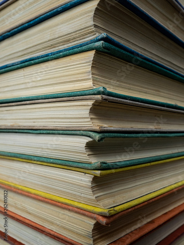 Heap of books of different flowers. The old books put on a table. The turned yellow pages of textbooks