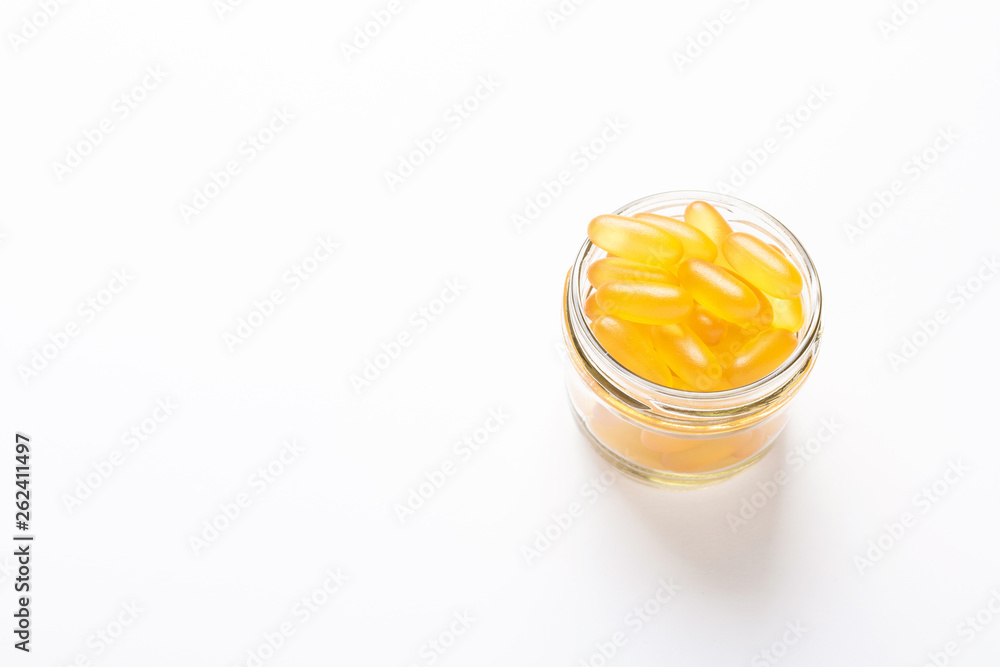 Omega 3 capsules in glass jar on white background Fish oil Yellow softgels Vitamin D, E, A supplement Omega 3 capsules in glass jar on white background Fish oil Yellow softgels Vitamin D, E, A supplement