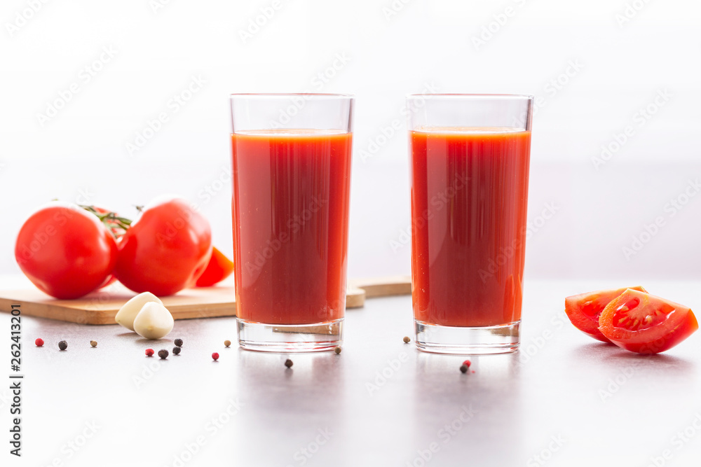 Fresh tomato juice with parsley and spices, selective focus. Glasses with tomato juice and fresh tomatoes on a table Fresh tomato juice with parsley and spices, selective focus. Glasses with tomato juice and fresh tomatoes on a table