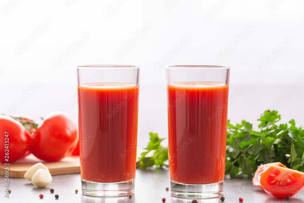 Fresh tomato juice with parsley and spices, selective focus. Glasses with tomato juice and fresh tomatoes on a table Fresh tomato juice with parsley and spices, selective focus. Glasses with tomato juice and fresh tomatoes on a table