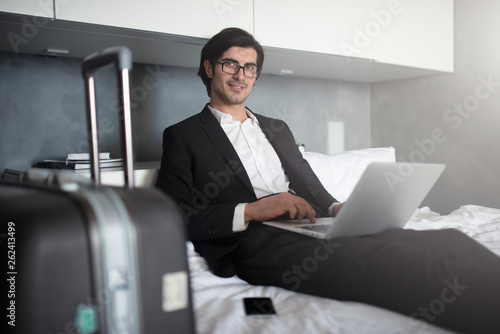 Businessman ready to travel works with his laptop