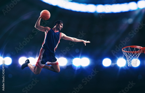 Acrobatic slam dunk of a basket player in the basket at the stadium © alphaspirit