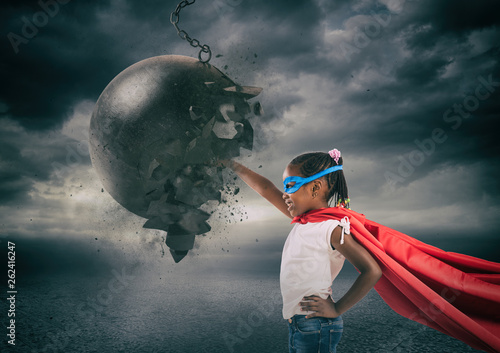 Power and determination of a super hero child against a wrecking ball photo