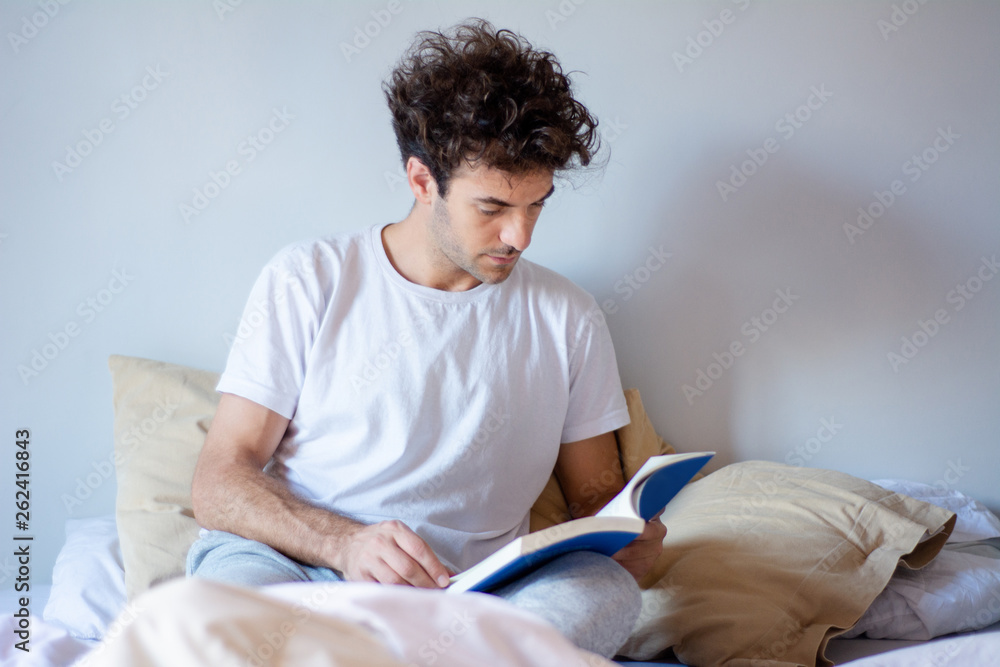 Man reading a book in bed Man reading a book in bed