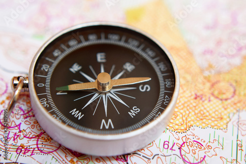 Obraz na plátně Round compass on colorful topographic map for orienteering or rogaining sport, close up view at shallow depth of field