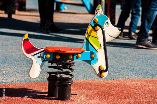 Children's swing in the shape of a dog on the spring in the park