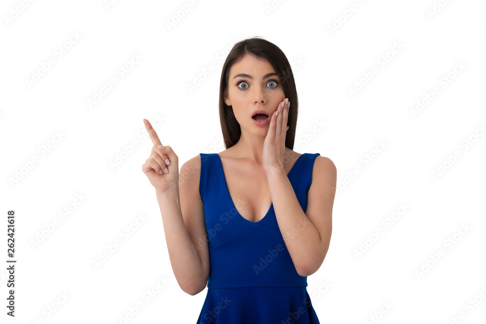 Surprised girl indicates a blank space for your text. Isolated on white background