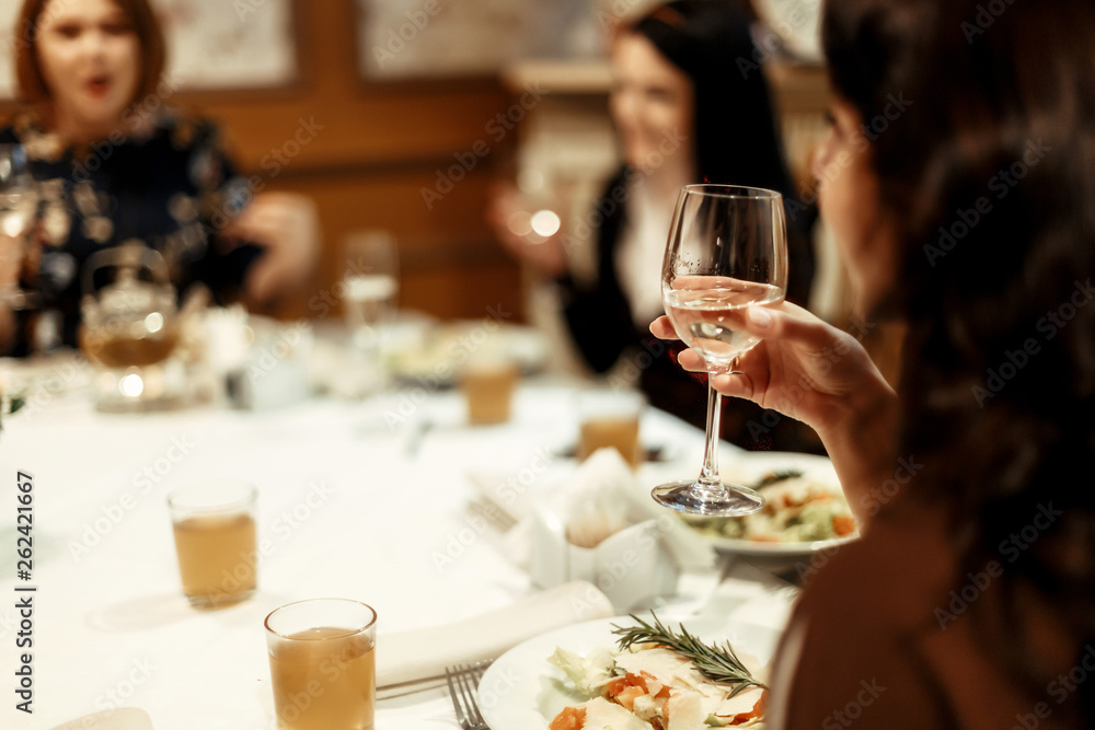 hand of stylish woman holding glass of champagne and toasting at luxury restaurant, space for text hand of stylish woman holding glass of champagne and toasting at luxury restaurant, space for text