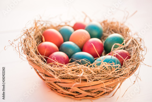easter colorful eggs in a basket spring concept on a white background with room for text