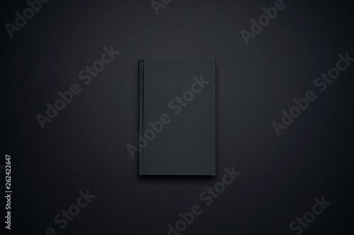 Canvastavla Mockup of blank black book template isolated on black background for your design