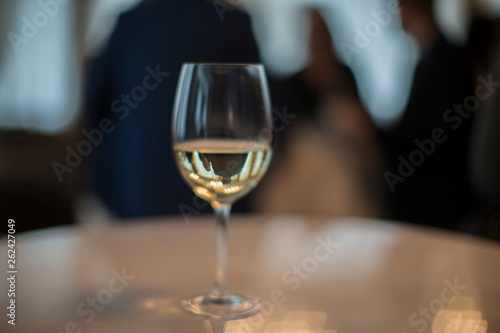 A glass filled with champagne on a table on a dark background