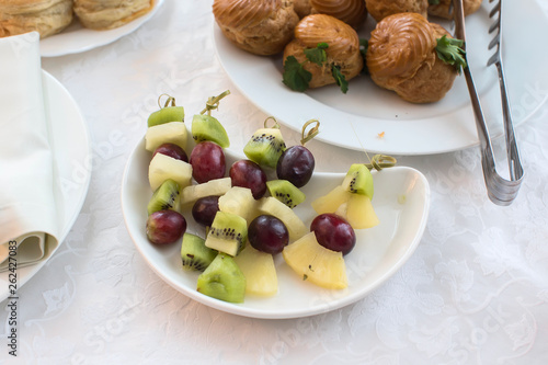 Buffet dishes.Canapes made from grapes of kiwi, apple