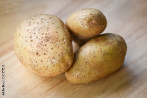 Fresh raw potato on wooden backgroun for