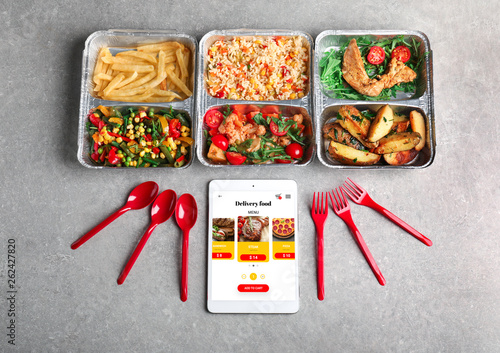 Composition with containers and tablet computer on light background. Concept of online food delivery