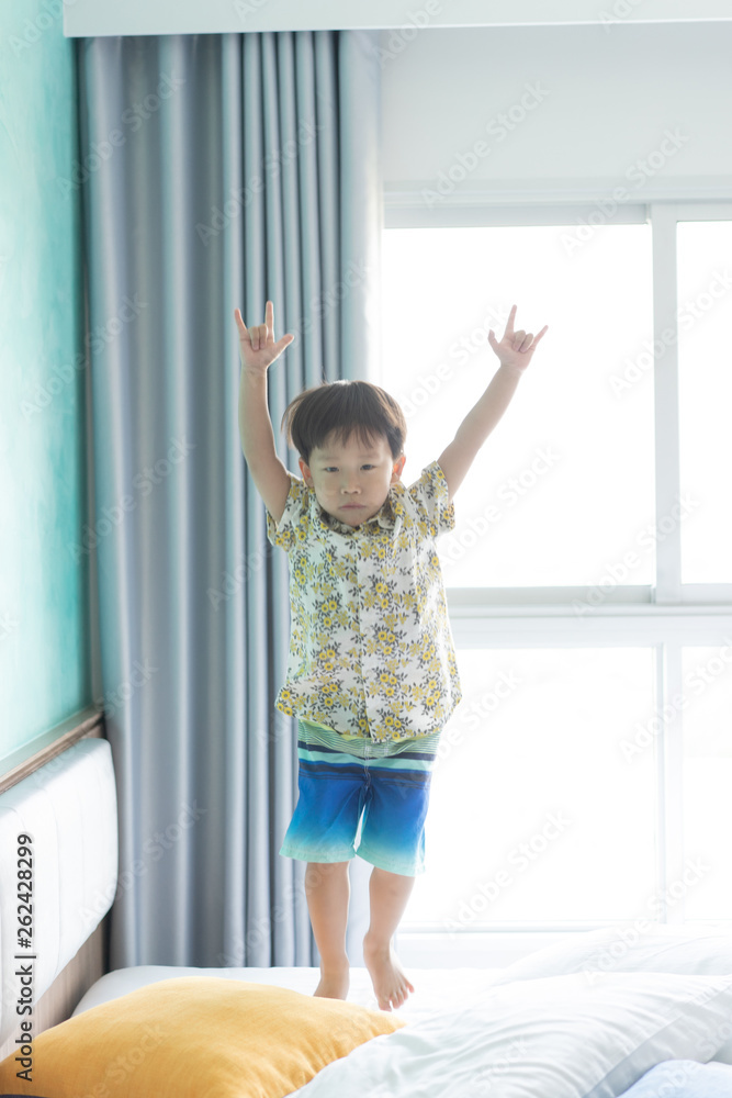 Boy is jumping and playing in the morning on the bed. Boy is jumping and playing in the morning on the bed.