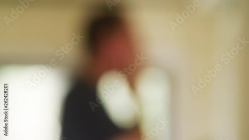 Out of focus bokeh man washes & cleanses face in bathroom