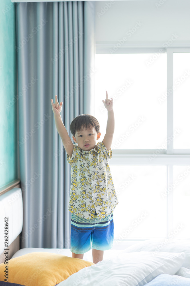 Boy is jumping and playing in the morning on the bed. Boy is jumping and playing in the morning on the bed.