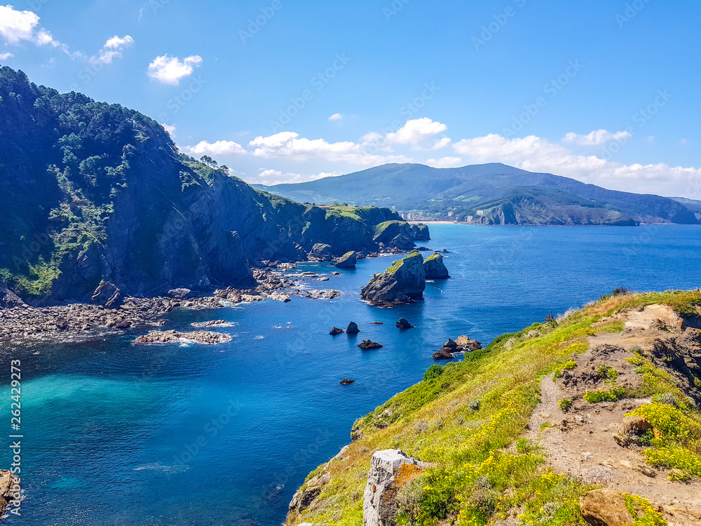 Hermitage of San Juan de Gaztelugatxe at the top of the island of Gaztelugatxe. Vizcaya, Basque Country (Spain). View of the Cantabrian Sea with blue sky.