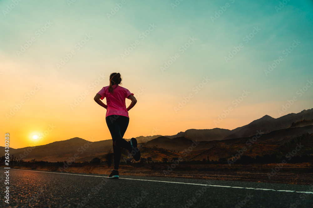 Woman enjoys running outside with beautiful summer evening in the countryside.