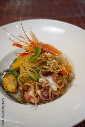 Spicy Seafood Spaghetti stir fried (Pad Cha) rolled in the fork on white dish of luxury restaurant