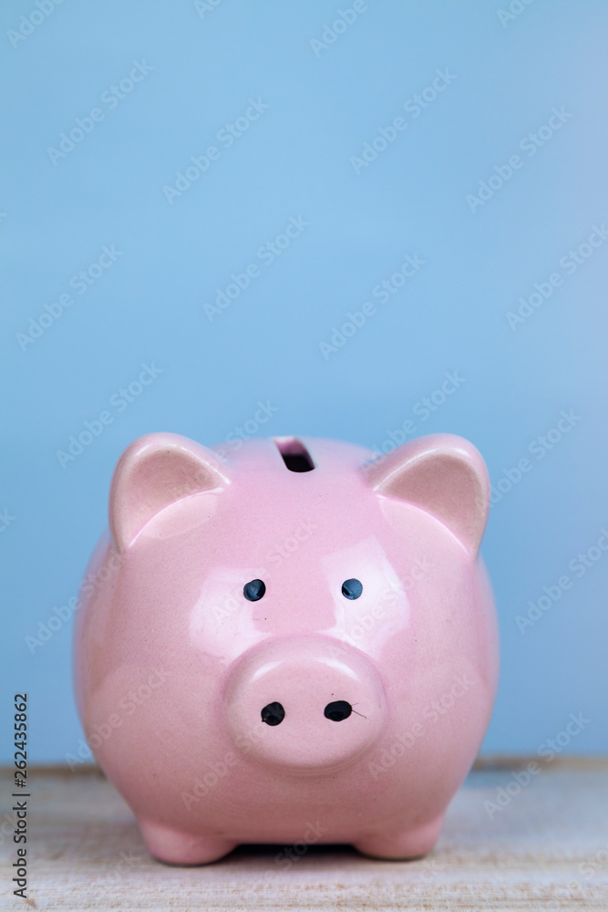 Pink pig money box on a wooden background