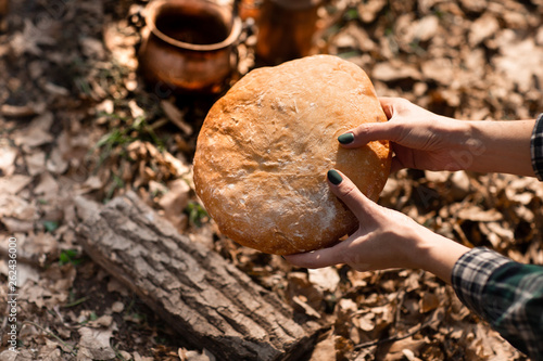 Wallpaper Mural Closeup of fresh rustsic bread in a woman's hand. The background of the forest Torontodigital.ca