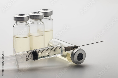 Subcutaneous syringe. Syringes with blue needles. Medical Injectors. Medical glass injection bottle. Ampoules with injections.