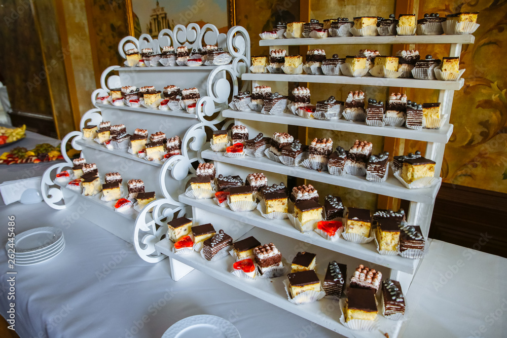 Delicious candy bar at the wedding reception. Chocolate cakes and muffins.Sweet red hearts. Desserts for guests.