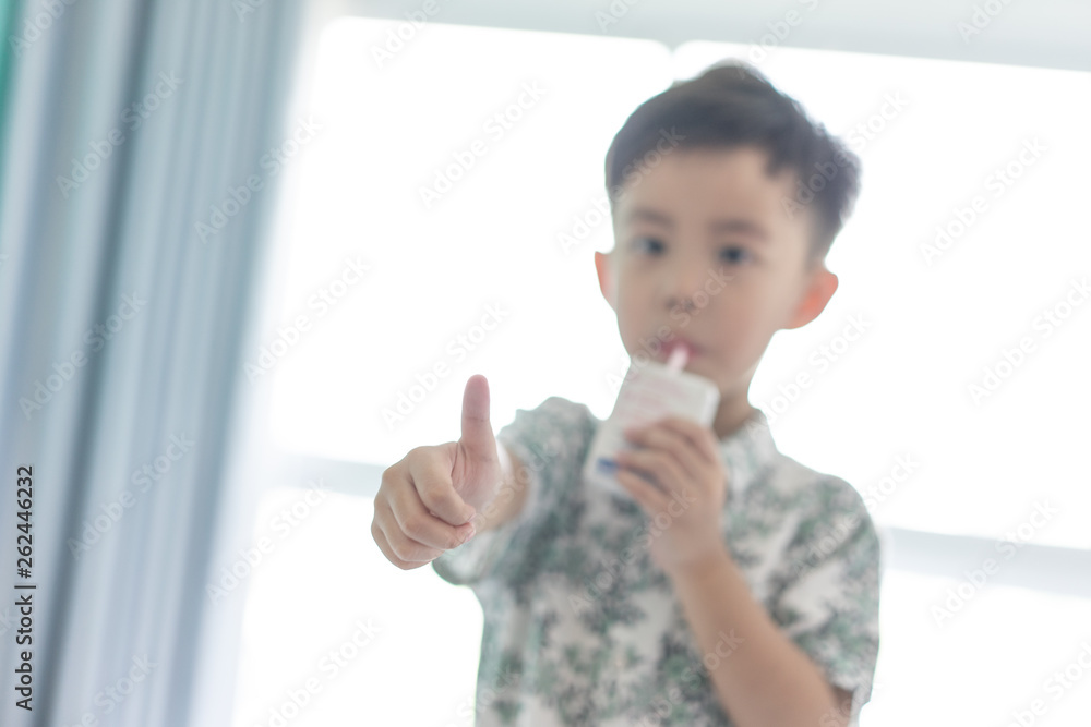 The boy is sucking milk from the milk box. He likes milk box so much. The boy is sucking milk from the milk box. He likes milk box so much.
