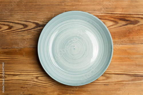 Fotografie Plato redondo celeste de cerámica sobre una mesa de madera rústica