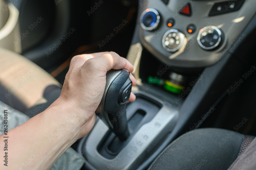 Naklejka premium Driver male hand holding automatic gear shift