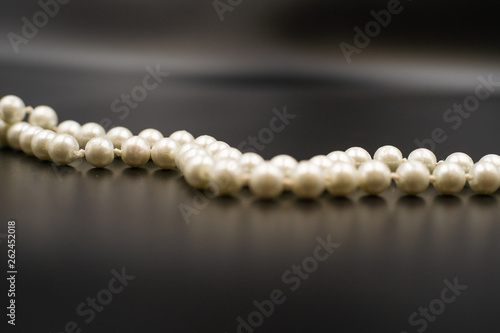 background image of white beads on black and gray background.