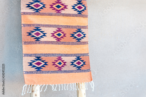 фотографія Traditional southwestern rug on display by adobe house wall, Taos, New Mexico, U