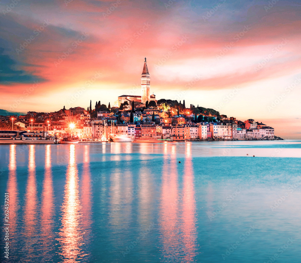 Beautiful  magical city landscape with sea, colorful houses and an ancient tower in Rovinj, Croatia at evening lights at sunset. popular tourist attraction. (vacation, rest - concept)