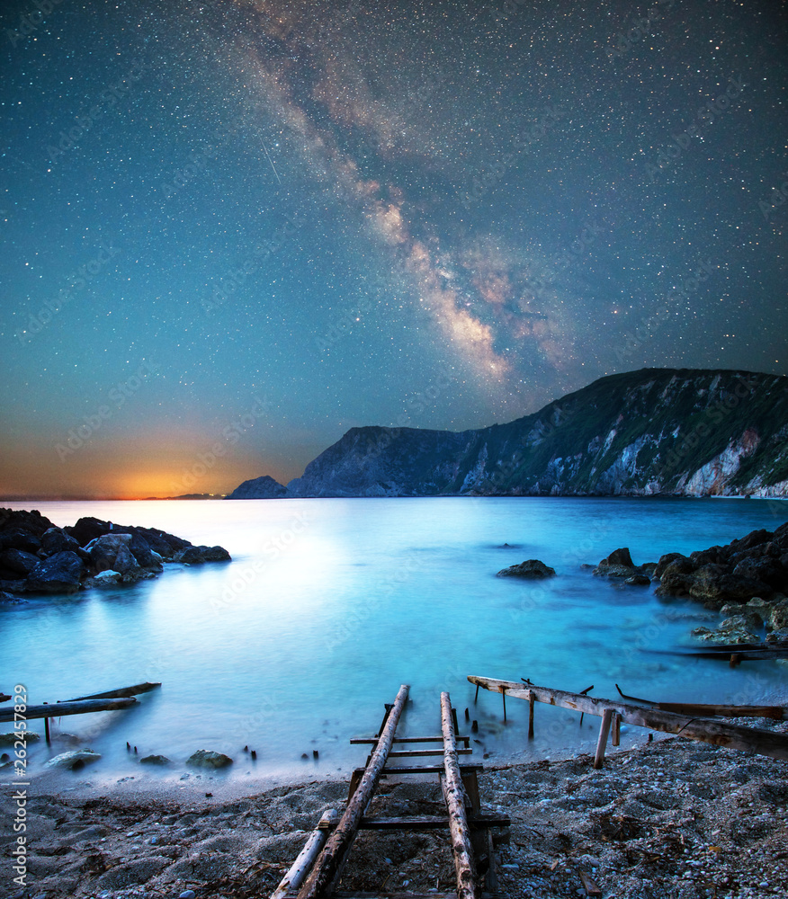 fascinating mystical magical landscape with a deach and boat racks at night in the light of the Milky Way stars