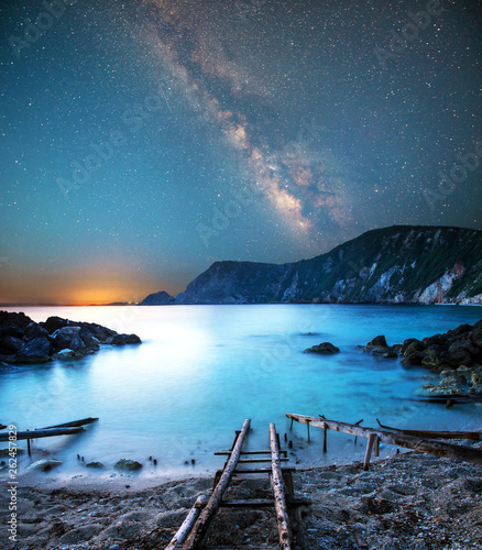 Obraz na płótnie fascinating mystical magical landscape with a deach and boat racks at night in the light of the Milky Way stars w salonie