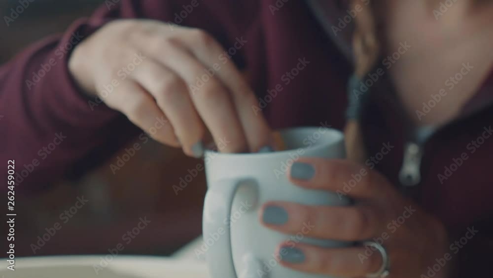Close up shot of a women dipping a rusk in a cup of coffee. Close up shot of a women dipping a rusk in a cup of coffee.