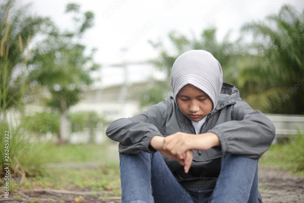 Muslim Girl Sitting on Ground in the Park Muslim Girl Sitting on Ground in the Park